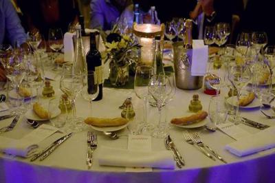 Table dressée pour un dîner élégant avec verres, assiettes, couverts, bougies et décorations florales.