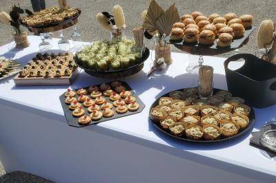 Buffet en plein air avec une variété de bouchées salées présentées sur une table blanche.