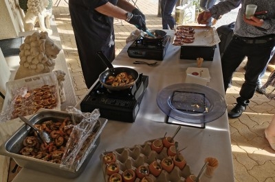 Traiteur Eclat des Saveurs Marles-en-Brie #5 Chef cuisinant des plats à base de crevettes et œufs devant une table dressée en extérieur.