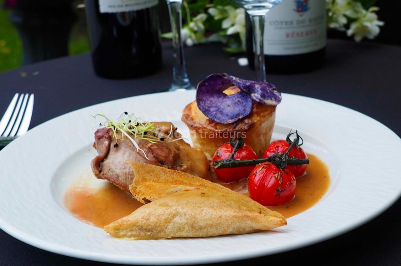 Traiteur France Evenement Traiteur Comines #1 Assiette gastronomique avec viande en sauce, légumes grillés, chips violettes et croustillant, servie sur une table élégante.