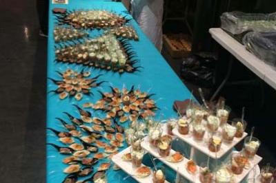 Traiteur L'escale Gourmande Maison Perochon Trappes #3 Buffet avec présentation soignée de plats variés, incluant fruits de mer, verrines et amuse-bouches, sur une nappe turquoise.