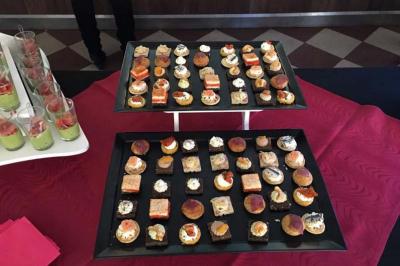 Traiteur L'escale Gourmande Maison Perochon Trappes #2 Plateaux de canapés variés disposés sur une nappe rouge, accompagnés de verrines en arrière-plan.