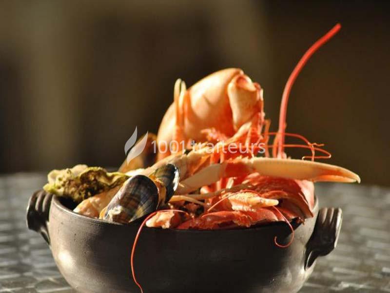 Traiteur La Clé en Main Urville #1 Assortiment de fruits de mer dans un plat en céramique, comprenant crevettes, coquillages et crustacés.