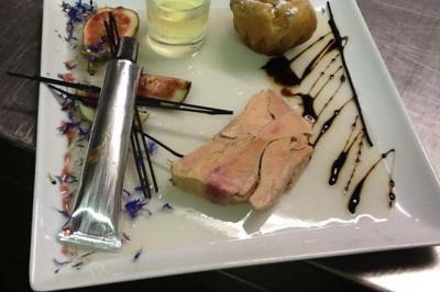 Assiette gastronomique avec foie gras, figue, pain, sauce balsamique, fleurs comestibles et verrine de gelée.