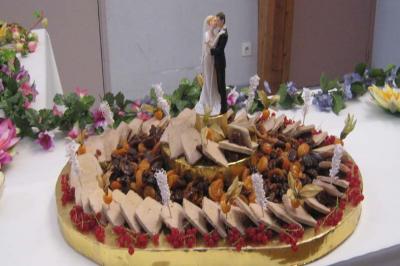 Plateau de foie gras décoré avec fruits secs, groseilles et figurine de mariage au centre, posé sur une table ornée.
