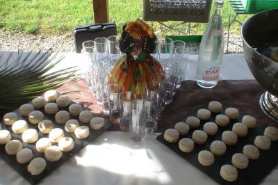 Plateau de macarons disposés autour de verres vides, d'une bouteille d'eau et d'une décoration colorée sur une table.