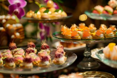 Assortiment de desserts colorés et raffinés présentés sur des plateaux en verre dans un cadre élégant.