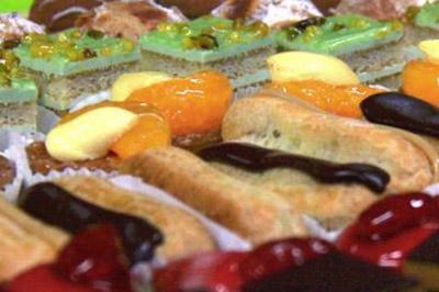 Assortiment de pâtisseries colorées comprenant éclairs, tartelettes aux fruits et gâteaux décorés.