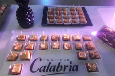 Plateau de verrines apéritives disposées sur une table avec une décoration en forme d'ananas noir.