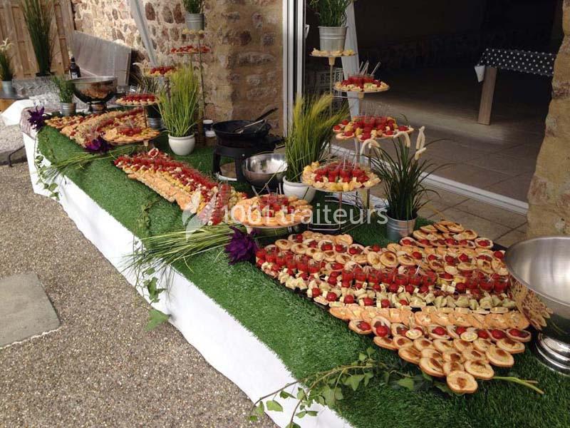 Traiteur Au Faim Délice Pont-Salomon #1 Buffet en extérieur avec une variété de plats et amuse-bouches disposés sur une table recouverte de gazon artificiel.