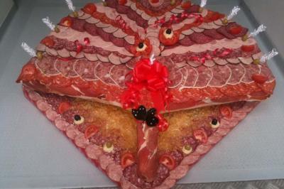 Traiteur Sandrine Traiteur Asnières-sur-Oise #4 Plateau de charcuterie en forme de paon, décoré de tranches de viande, olives, tomates et rubans rouges.