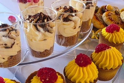 Traiteur Royal Events Traiteur et Tradition Saint-Cyr-en-Val #5 Desserts variés présentés sur un plateau, incluant verrines à la crème et tartelettes garnies de framboises.