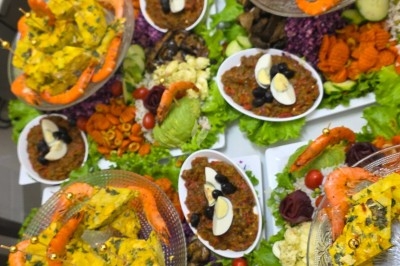 Traiteur Royal Events Traiteur et Tradition Saint-Cyr-en-Val #2 Plats variés composés de salades, crevettes, œufs, olives et légumes, présentés sur une table garnie de verdure.