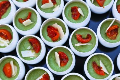 Traiteur Maison Tess Traiteur Paris 17 #3 Petits contenants remplis de mousse verte garnie de morceaux de tomates confites et copeaux de fromage.