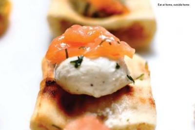 Traiteur Sarah Lima Traiteur Brésilien Élancourt #5 Canapé garni de fromage frais, saumon fumé et herbes, présenté sur une base de pain grillé.