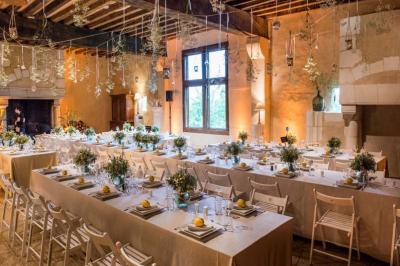 Traiteur Sarah Lima Traiteur Brésilien Élancourt #3 Salle de réception décorée avec des tables alignées, nappes blanches, chaises pliantes et ornements suspendus.