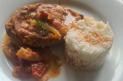 Traiteur BAC Traiteur Charly-sur-Marne #4 Assiette contenant une tranche de viande en sauce avec des légumes et un accompagnement de riz blanc saupoudré de paprika.