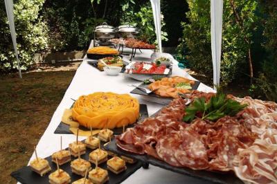 Table dressée en extérieur avec un buffet varié comprenant charcuterie, fromage, fruits et plats froids.
