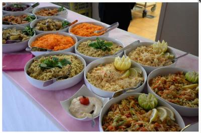 Traiteur Plancha Seclin #4 Buffet de salades variées avec carottes râpées, taboulé, légumes, et sauce, présenté dans des bols sur une nappe rose.