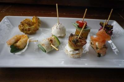 Assortiment de bouchées apéritives variées présentées sur une assiette rectangulaire blanche.