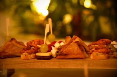 Assortiment de bouchées apéritives variées disposées sur un plateau en bois, avec un arrière-plan flou et lumineux.