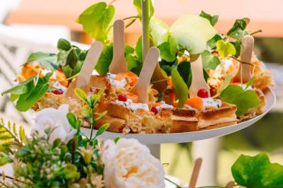 Assiette garnie de gaufres décorées de fruits et de crème, entourée de feuillage et de fleurs.