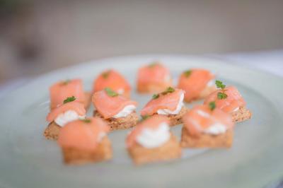 Assortiment de canapés au saumon fumé, crème et herbes fraîches, disposés sur une assiette claire.