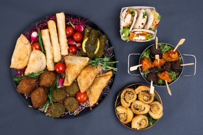 Assortiment de mezzés comprenant samoussas, falafels, feuilles de vigne, wraps, brochettes et roulés apéritifs.