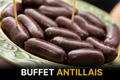 Assiette de boudins antillais présentés sur un plat en céramique verte avec des piques en bois.