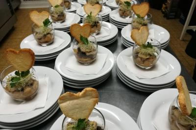 Verrines garnies de champignons, herbes fraîches et toasts en forme de cœur, disposées sur des assiettes blanches.