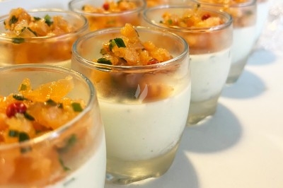 Traiteur Chica et Cocco Saint-Germain-en-Laye #4 Verrines de panna cotta salée garnies de tartare de saumon et herbes fraßches, présentées sur une table blanche.