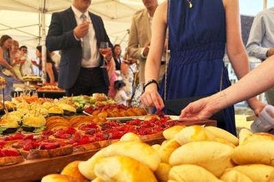 Traiteur Chica et Cocco Saint-Germain-en-Laye #2 Buffet en plein air avec des invités se servant parmi des plats variés, incluant pains, viennoiseries et amuse-bouches.