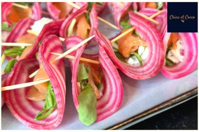 Tranches de betterave chioggia garnies de saumon fumé, fromage frais et roquette, maintenues par des piques en bois.