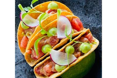 Traiteur Ô Saveurs d’Antoine Agde #2 Trois tacos garnis de poisson cru, radis, coriandre et crème verte, présentés sur une surface noire.