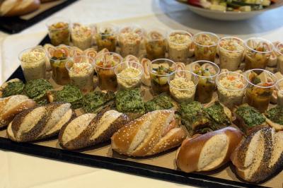 Traiteur Traiteur une Faim d'Apprendre Lyon 9 #5 Plateau de buffet avec pains variés, verrines de salades et portions de quiches aux légumes.