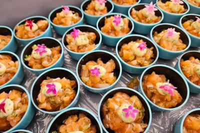 Traiteur Concept Catering Events Cannes #4 Coupes individuelles de tartare de saumon garnies de sauce et de petites fleurs comestibles roses.