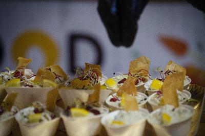 Coupes individuelles garnies de mousse blanche, morceaux de mangue, herbes fraîches et chips croustillantes.
