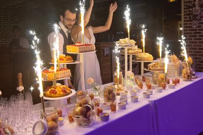 buffet de desseets Table de desserts décorée avec des fontaines lumineuses, comprenant gâteaux, verrines et autres douceurs dans un cadre…