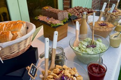 buffet froid Buffet avec pain, pâté, salades variées, pâtes, sauces et condiments disposés sur une table blanche.