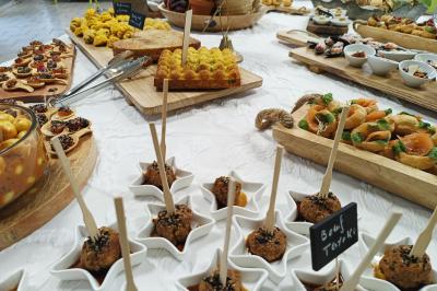 Traiteur Ardélices Buffet Breuillet #3 Buffet varié avec amuse-bouches, verrines, tartes salées et plats colorés disposés sur une nappe blanche.