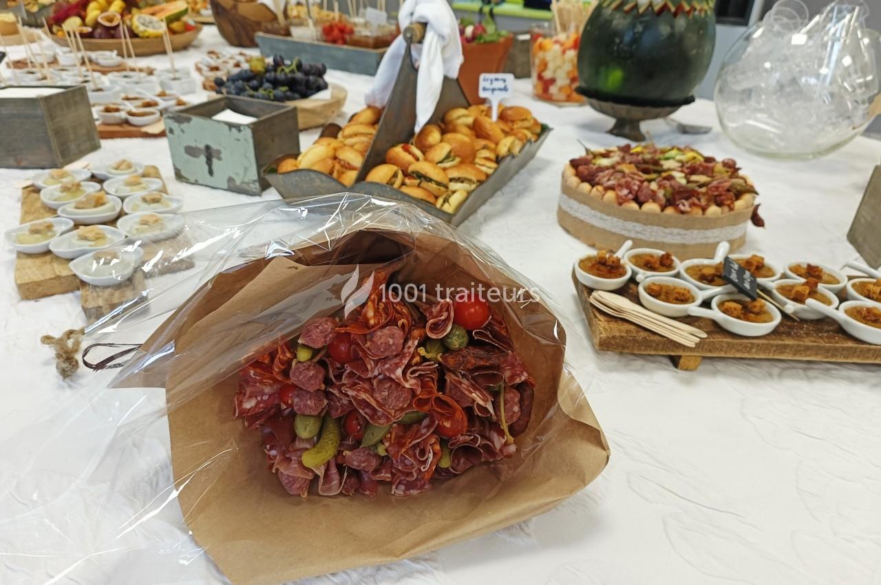 Traiteur Ardélices Buffet Breuillet #1 Plateau de buffet avec un bouquet de charcuterie au premier plan, entouré de divers amuse-bouches et desserts.