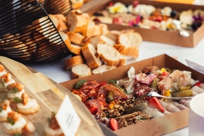 Planches & Buffets Buffet avec planches de charcuterie, pains, canapés et légumes, présenté sur une table en extérieur.