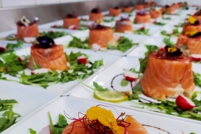 Traiteur Le Quai Fleuri Les Villages Vovéens #2 Assiettes de saumon fumé dressées sur un lit de roquette avec des garnitures colorées et des fleurs comestibles.