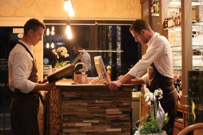 Deux serveurs en tablier travaillent au comptoir d'un restaurant éclairé par une lumière chaleureuse.
