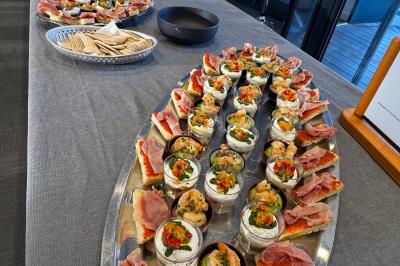 Plateau de bouchées apéritives variées disposées sur une table, comprenant charcuterie, verrines et toasts.