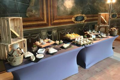 Table de buffet avec une sélection de fromages, pains et accompagnements, présentée dans un cadre élégant.