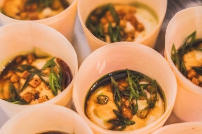 Petits contenants en bois remplis de purée garnie de morceaux croustillants et d'oignons verts émincés.