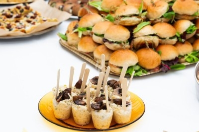 Traiteur Montagu Paris 11 #5 Buffet avec mini-sandwichs, roulés, verrines et autres amuse-bouches disposés sur une table blanche.