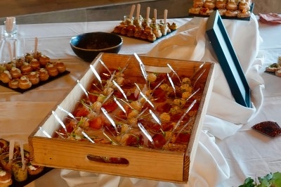 Plateau de verrines et assortiments de bouchées salées disposés sur une table blanche dans un cadre intérieur.