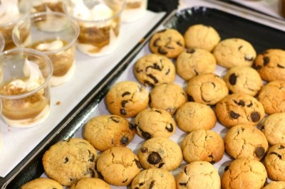 Traiteur Montagu Troyes #5 Plateaux de cookies aux pépites de chocolat et verrines de dessert disposés sur une table.